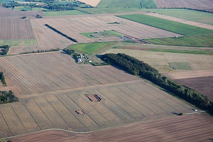 Grabungsschnitte im Umfeld der Anlage von Schnebeck (Vordergrund) und das rekonstruierte Ringheiligtum Pmmelte im Hintergrund.